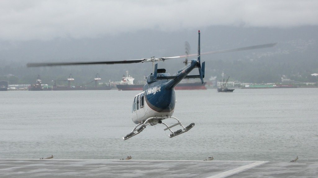 Helijet Bell LongRanger lifts off from the Vancouver Harbour Heliport on a cloudy day.