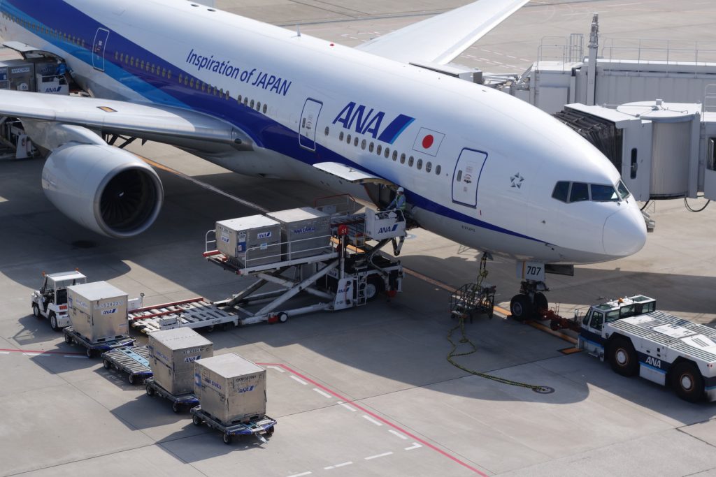 Pods being loaded into an ANA 777-200. Look for the two ground power cables by the nosewheel.
