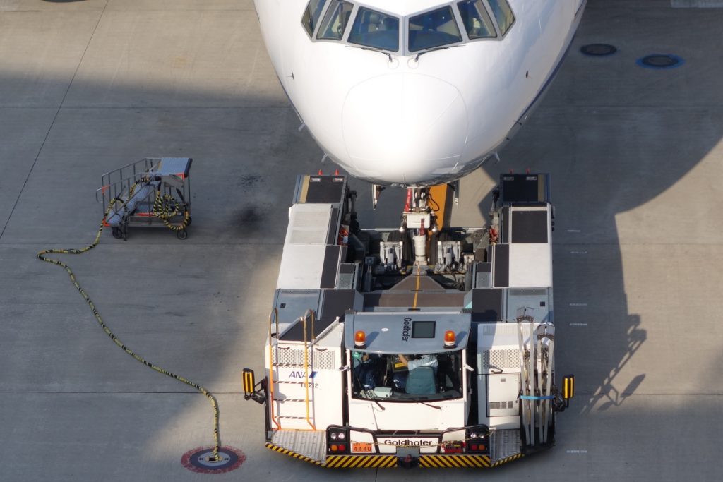 A wheel-lift tug ready to move an empty ANA 777 at Tokyo-Haneda. Look carefully, you can see the "Remove Before Flight" banner and pin on the nosegear.