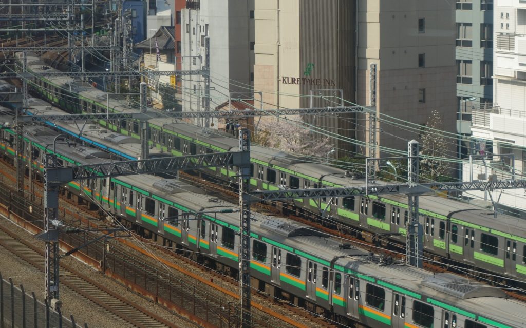 Transit trains in Tokyo - the double-green striped train is the Yamanote Line.