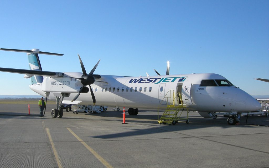 Westjet Encore Bombardier Q400 C-FENY at North Peace Regional Airport (YXJ) in Ft. St. John BC, under a beautiful blue sky. 